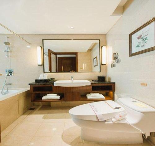 a bathroom with a toilet and a sink and a tub at Grand Soluxe Zhongyou Hotel Shenzhen in Shenzhen