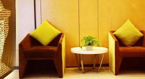 two chairs and a table in a room at IU Hotel Chengdu High-Tech Zone Longhu Times Street in Chengdu