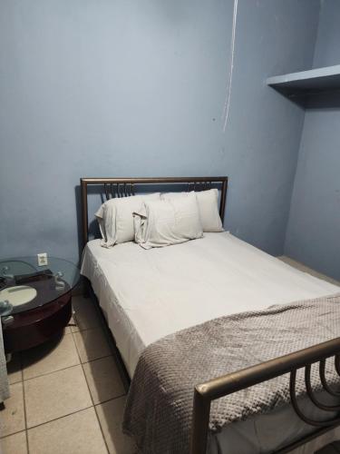 a bed with white pillows in a bedroom at Townhouse in Siguatepeque
