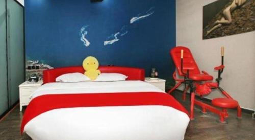 a bedroom with a red and white bed and a red chair at Thank Inn Hotel He'nan Xinxiang Changyuan Bo'ai Road in Changyuan