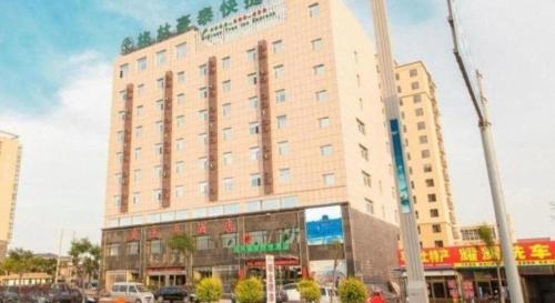 a large white building in a city with cars at GreenTree Inn Jinzhong PinGYAo City South Railway Station Express Hotel in Pingyao