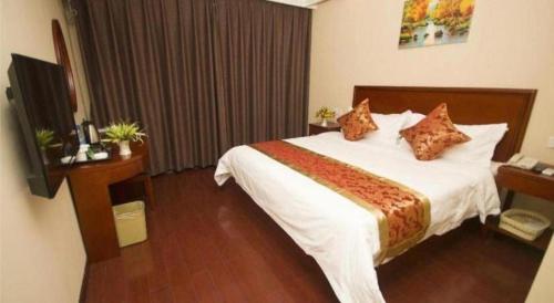 a hotel room with a large bed and a television at GreenTree Inn Jinzhong PinGYAo City South Railway Station Express Hotel in Pingyao