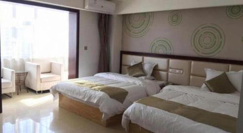 a bedroom with two beds and a chair and a window at GreenTree Inn Jinzhong PinGYAo City South Railway Station Express Hotel in Pingyao