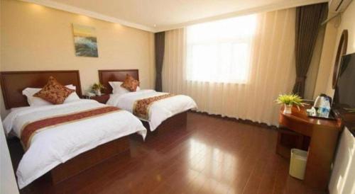 a hotel room with two beds and a window at GreenTree Inn Jinzhong PinGYAo City South Railway Station Express Hotel in Pingyao