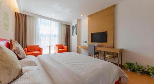 a hotel room with a bed and a television at GreenTree Inn Nantong University Industrial Expo City Express Hotel in Nantong