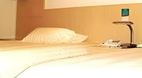 a white bed with a laptop on top of it at Jinjiang Inn Wenzhou Shuangyu The Terminal in Wenzhou