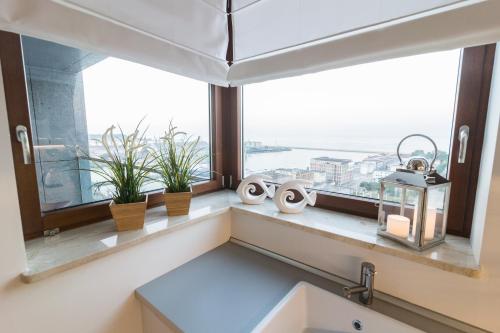un bagno con finestra con piante su un cornicione di Ocean Dream - Sea Towers a Gdynia