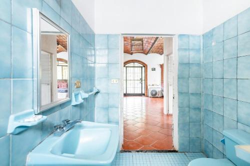 a blue tiled bathroom with a sink and a mirror at Beautiful Beach House in Lo De Marcos, Nayarit! in Lo de Marcos