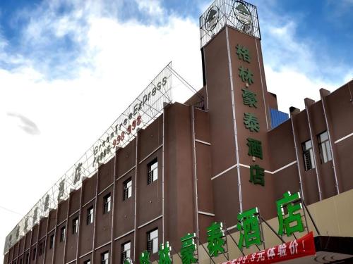 a building with a clock tower on top of it at GreenTree Inn Haixi Geermu Southern suburbs Express Hotel in Golmud