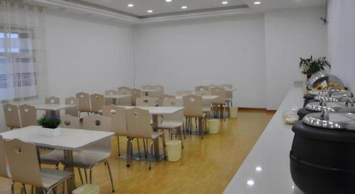 an empty room with tables and chairs in a room with at GreenTree Inn Haixi Geermu Southern suburbs Express Hotel in Golmud