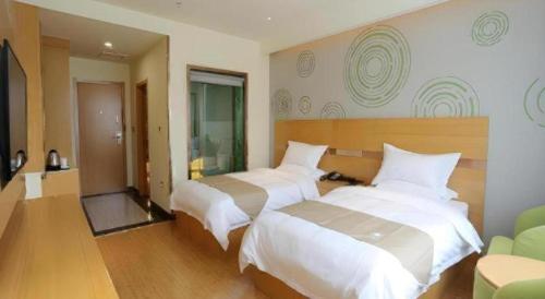 a hotel room with two beds and a couch at GreenTree Inn Tibet Nyingchi City Biji Shenshan in Nyingchi