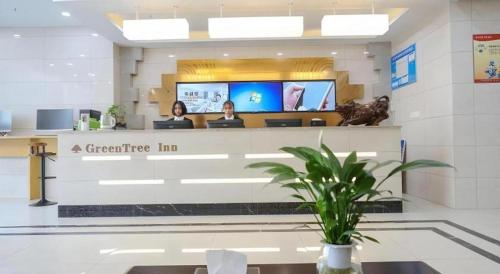 two people sitting at the counter of a dental office at GreenTree Inn Jiaxin Puyuan Kaixuan Road in Jiaxing