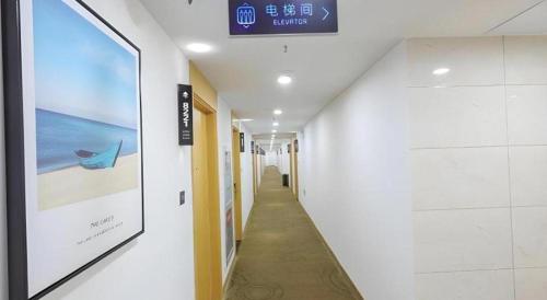 a hallway in a building with a sign on the wall at GreenTree Inn Jiaxin Puyuan Kaixuan Road in Jiaxing