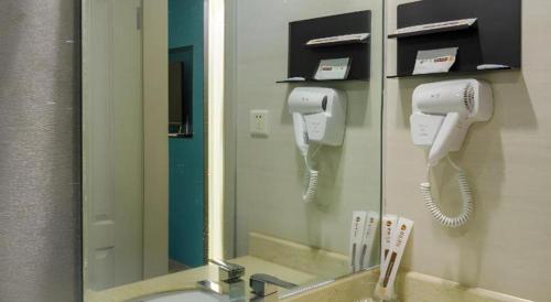 a bathroom with a mirror and a hair dryer at Jingtu hotel zhanjiang dingsheng plaza store in Zhanjiang