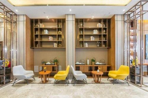 a lobby with yellow chairs and tables and shelves at Yitel Collection Harbin Railway Station Museum Metro Station in Harbin