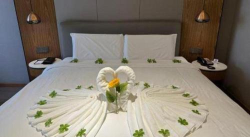 a white bed with a flower decoration on it at Yitel Collection Harbin Railway Station Museum Metro Station in Harbin