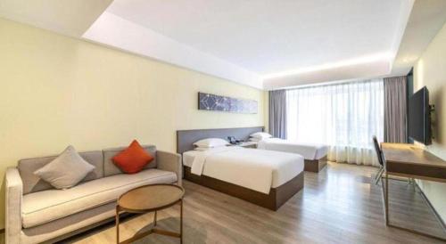 a hotel room with a bed and a couch at AURAYA BY SUNING NANJING XUZHUANG in Nanjing