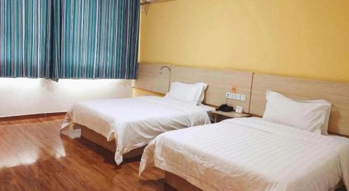 a room with two beds in a hotel room at 7 Days Inn Yining Xintiandi in Kipekyüzi