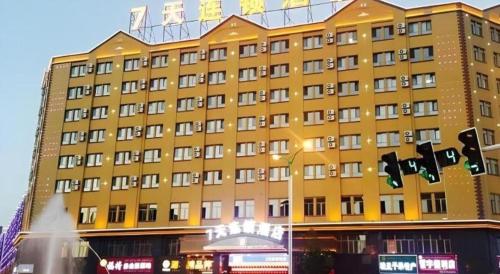 a yellow building with a traffic light in front of it at 7 Days Inn Yining Xintiandi in Kipekyüzi
