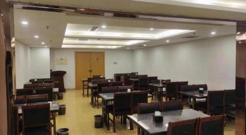 a room filled with tables and chairs and a room filled with tables at GreenTree Inn Ordos Kangbashi District Ulan Mulun Street Branch in Ordos