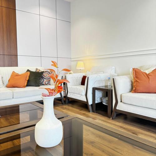 a living room with two couches and a vase at Crystal Chalet Al-Aredh كريستال العارض in Riyadh