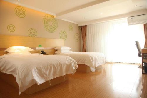 a hotel room with two beds and a window at GreenTree Inn Beijing Shunyi Fengbo Metro Station in Beijing