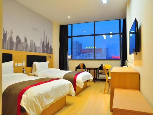 a hotel room with two beds and a window at Thank Hotel Jiangxi Jiujiang Lianxi District Railway Station Square in Jiujiang