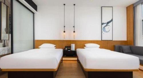 two beds in a room with a couch at Fairfield by Marriott Baoding High-Tech Zone in Baoding