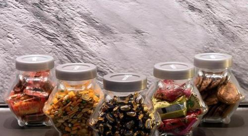 three glass jars filled with different types of food at The Keong Saik Hotel in Singapore
