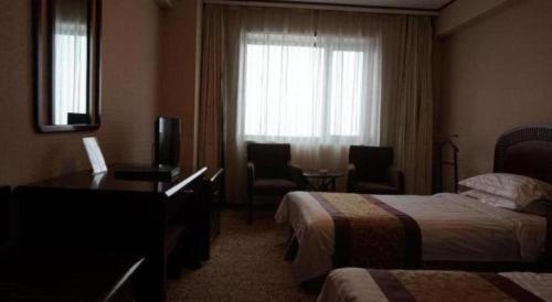 Postel nebo postele na pokoji v ubytování Heilongjiang Kunlun Hotel