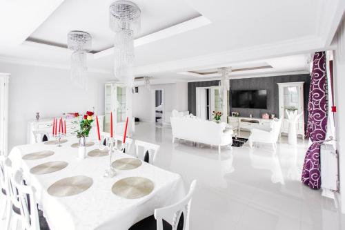 a white dining room with white tables and white chairs at Pensiunea Primaverii in Satu Mare