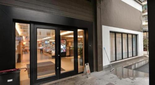 a building with glass doors on the side of it at Home Inns Plus Shanghai Xujiahui Branch in Shanghai
