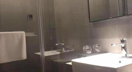 a bathroom with a shower and a sink and a mirror at Home Inns Plus Shanghai Xujiahui Branch in Shanghai