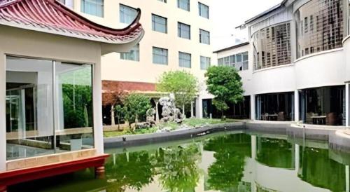 a building with a pool of water in front of a building at Huangshan Shuguang Yusong Hotel in Huangshan
