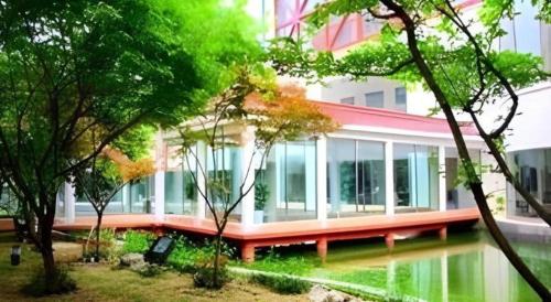 a building with a lot of windows and trees at Huangshan Shuguang Yusong Hotel in Huangshan