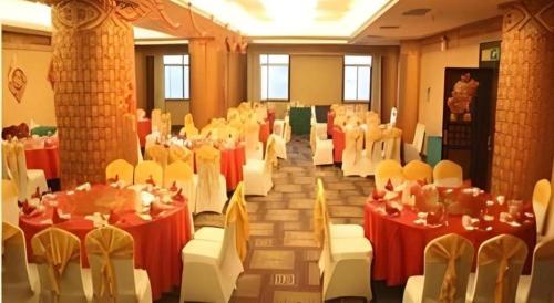 a banquet hall with red and white tables and chairs at Datong Tiangui International Hotel in Datong