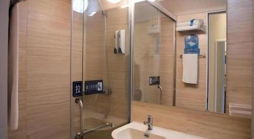 a bathroom with a sink and a shower with a mirror at 7 Days Inn Xi'an North Economic Development Zone 4th Fengcheng Road in Xi'an