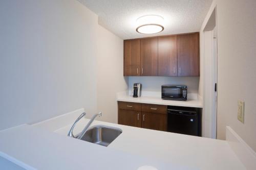 a small kitchen with a sink and a microwave at Holiday Inn Express Roseville-St. Paul by IHG in Roseville