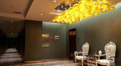 a lobby with chairs and a chandelier in a building at Harbin Ju Jian Hotel in Harbin
