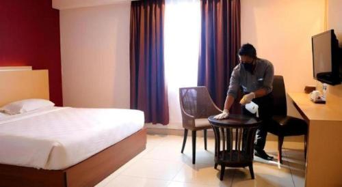 a man sitting at a desk in a hotel room at Borneo Hotel in Pontianak