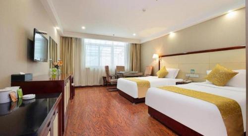 a hotel room with two beds and a desk at GreenTree Inn Taiyuan PinGYAng Road Business Hotel in Taiyuan