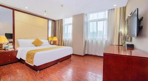 a hotel room with a bed and a flat screen tv at GreenTree Inn Taiyuan PinGYAng Road Business Hotel in Taiyuan