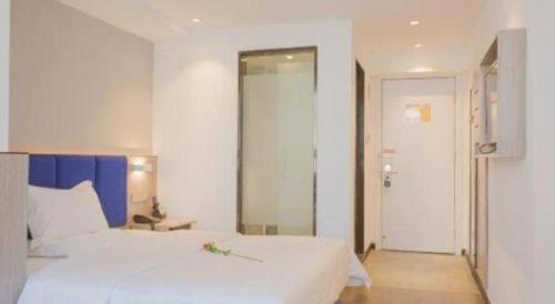 Ένα ή περισσότερα κρεβάτια σε δωμάτιο στο 7 Days Premium Qingdao Railway Station Zhanqiao Badaxia Plaza