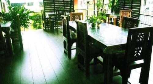 a wooden table and chairs in a restaurant with a table and chairsktop at Ritzy House Hotel in Chumphon