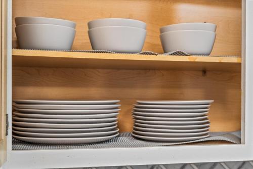 a shelf with white plates in a cabinet at Blue Havens in Rowlett