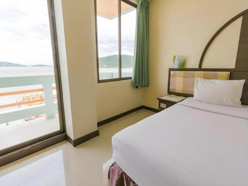 a bedroom with a bed and a large window at Lake Inn Hotel in Songkhla