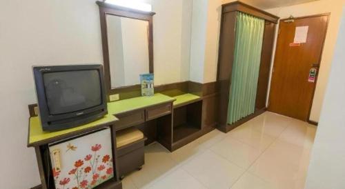 a room with a tv and a bathroom with a mirror at Lake Inn Hotel in Songkhla