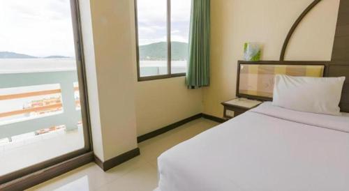a hotel room with a bed and a window at Lake Inn Hotel in Songkhla