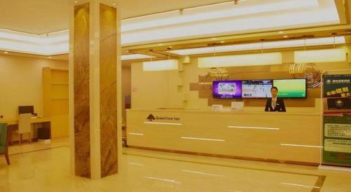 a lobby with a counter and a tv in a building at GreenTree Inn Qingyuan Qinghe Avenue Branch in Qingyuan
