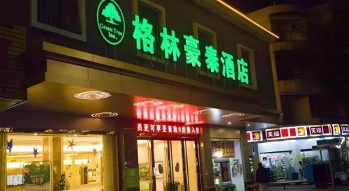 a store with neon signs on the side of a building at GreenTree Inn Qingyuan Qinghe Avenue Branch in Qingyuan